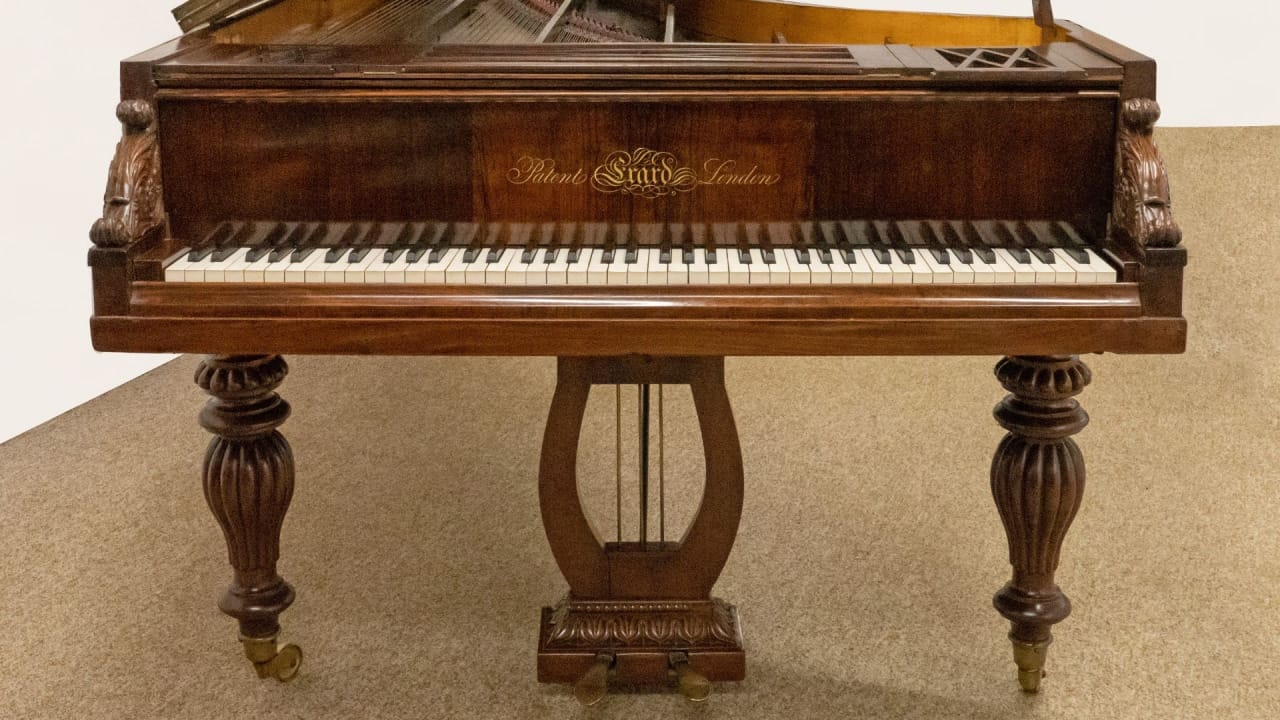 A picture of a mahogany-coloured grand piano made by the Erard piano company.
