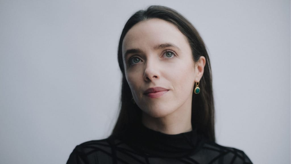 A head and shoulders photo of the mezzo-soprano Angharad Rowlands, a white woman with long dark hair and blue eyes.