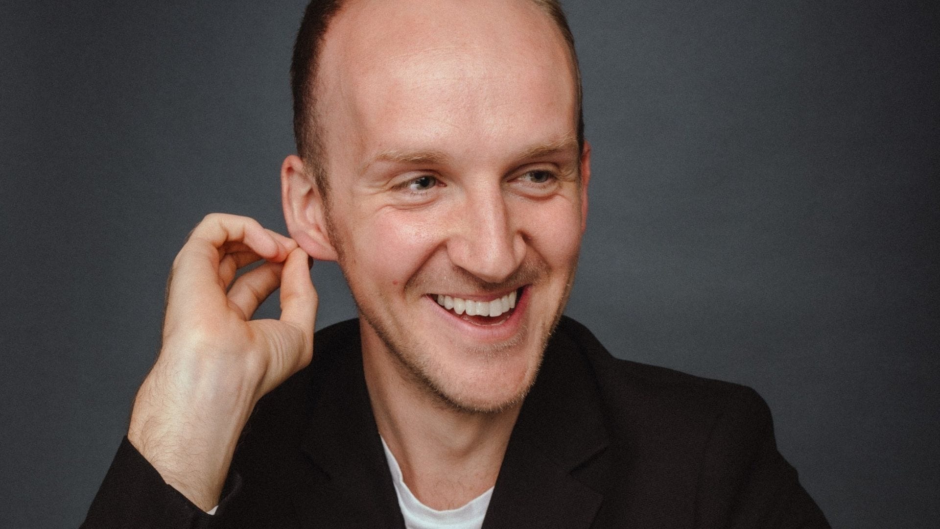 A headshot of the baritone Peter Edge, a white man with short hair who is smiling.