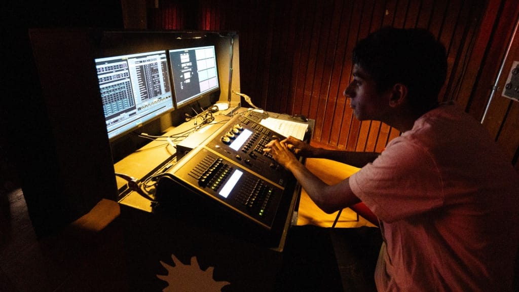 One of the OAE's Dreamchasing Young Producer operating a computerised lighting board at a show
